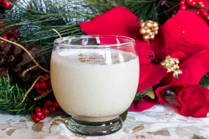 keto eggnog in a small glass with poinsetta in the background