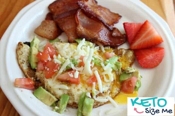 keto breakfast of eggs, avocado, cheese, strawberries on a plate