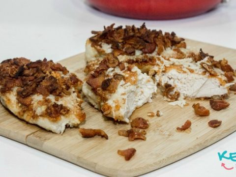 Keto Fried Chicken on cutting board with skillet in the background