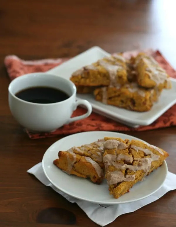 Plate with Keto Pumpkin Scones with Cinnamon Glaze and a cup of coffee