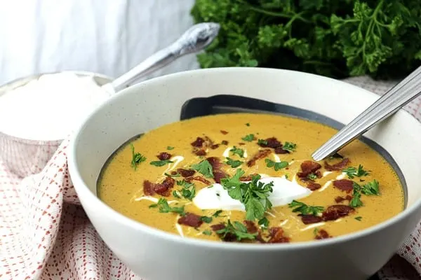 bowl of pumpkin soup topped with bacon