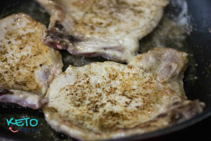 Browning pork chops before slow cooking.