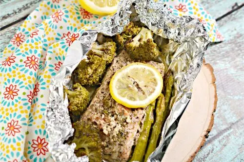 Low Carb Garlic Herb Salmon Foil Packets on a plate with a napkin in the background 