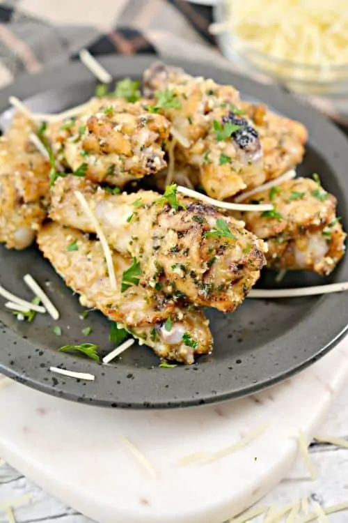 parmesan topped chicken wings on a plate 