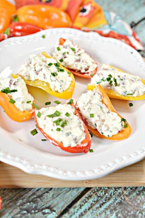 red and yellow cheese stuffed mini peppers arranged on a white plate