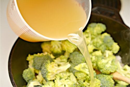 chicken broth being poured over broccoli   