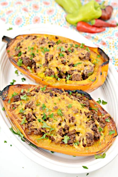 spaghetti squash cut in half and filled with taco meat and cheese and served on a white platter 