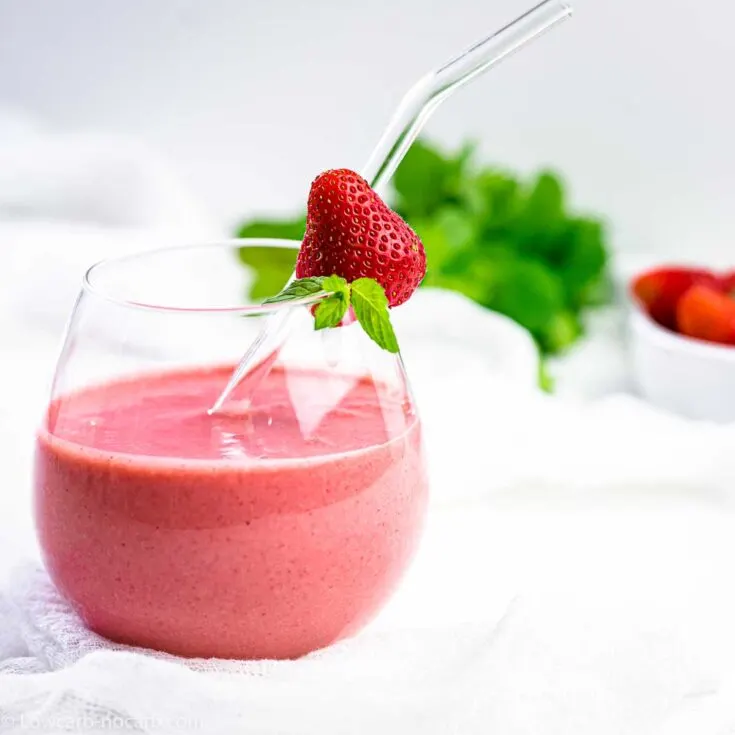 strawberry smoothie in a glass with a straw