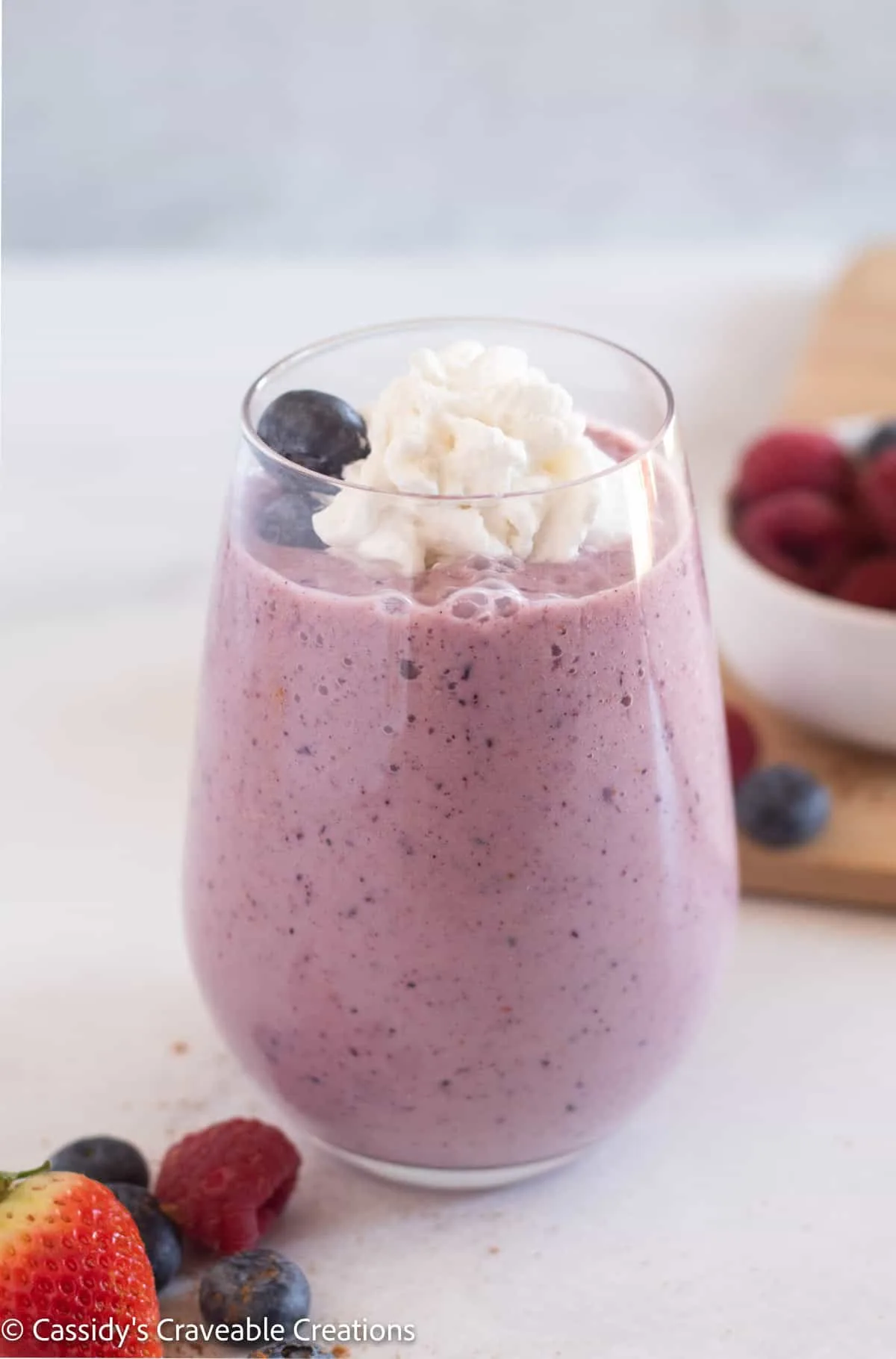 keto berry smoothie in a glass with whipped cream